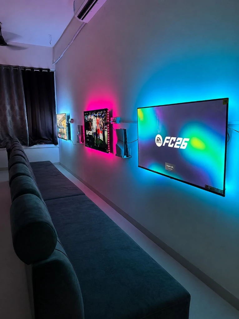 PS5 gaming setup with a big-screen TV and pink and blue lighting at Krypt Gaming